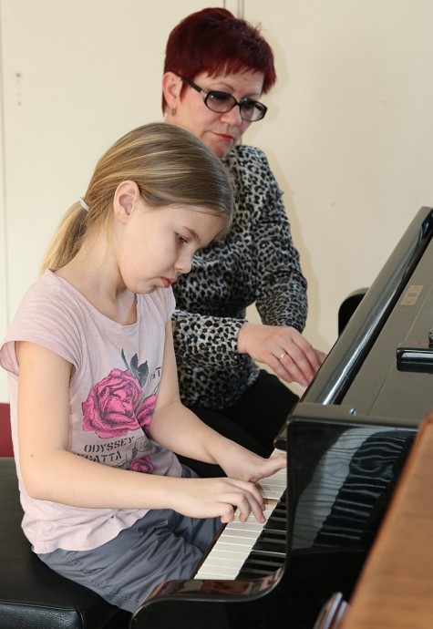 Õpetaja Bogdana Smagol ja 3. klassi õpilane Elise Pihlakas kooli esimese renoveeritud klaveri taga. Foto: Mart Kuus