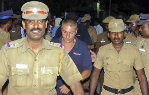 Indian policemen escort crew members of Sierra Leone-flagged ship Seaman Guard Ohio outside a court in Tuticorin