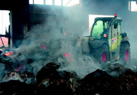 Kirbla põllumajandusühistu traktorist vedas eile Vanamõisa küünist välja põlevat heina, et see väljas ise kustuks. Foto: Katrin Pärnpuu