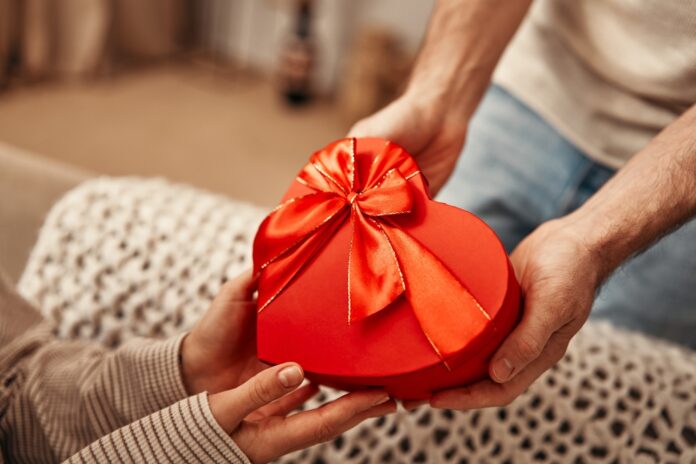 Happy,Valentine's,Day.,A,Man,Gives,A,Heart-shaped,Gift,Box